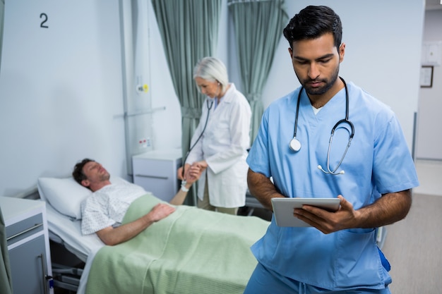 Surgeon using digital tablet in ward