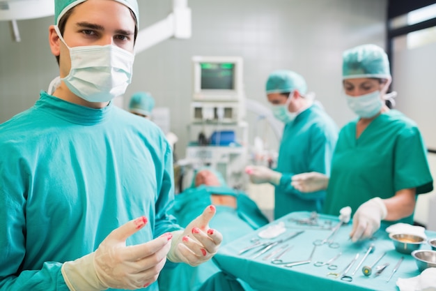 Surgeon wearing gloves with blood