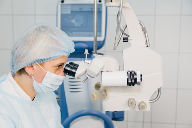 Хирург с операционной системой лазерной коррекции зрения в операционной.