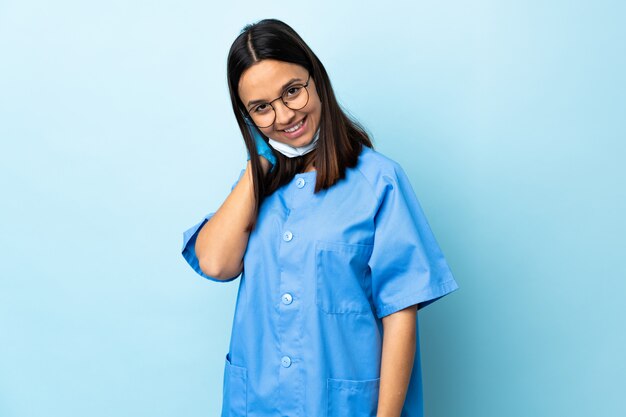 웃 고 파란색 벽을 통해 외과 의사 여자