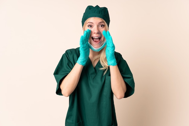 口を大きく開いて孤立した叫びに緑の制服を着た外科医女性