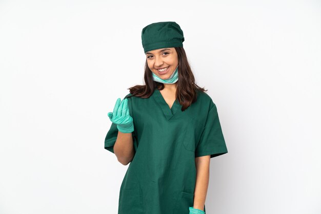 Surgeon woman in green uniform on white inviting to come with hand. Happy that you came