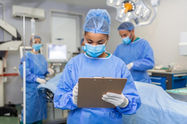 Photo surgeon writing on clipboard in operation room anaesthesiologist writing the updates