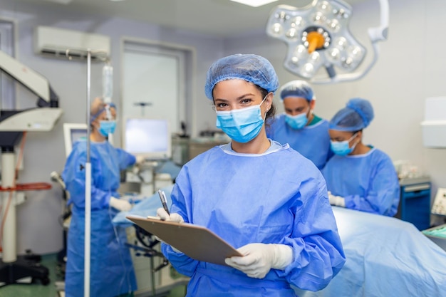 Photo surgeon writing on clipboard in operation room anaesthesiologist writing the updates