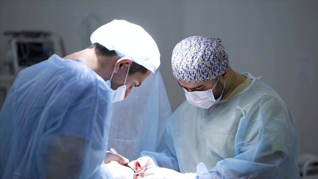 外科医は傷を焼灼し、プロの外科医は下で集中手術を実行します