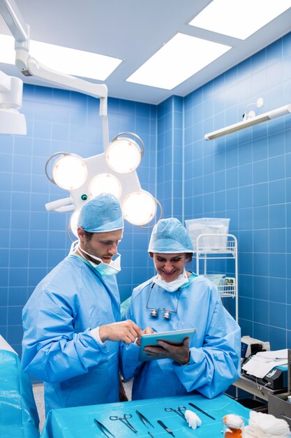 Surgeons discussing over digital tablet in operation room