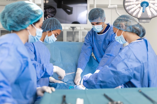 Surgeons doing surgery in operating theatre Male and female surgeons operating patient Medical professionals are wearing scrubs