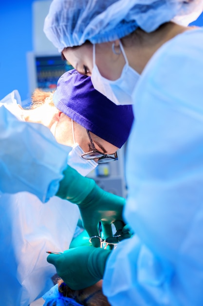 Foto chirurghi che gestiscono un paziente in sala operatoria