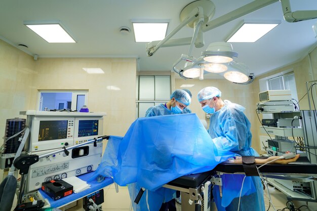 Surgeons working in operating room. Hospital background. Doctors at work. Circular background of an operation on a spinal cord, vertebra