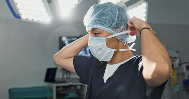 Surgery doctor and man with face mask in hospital theatre for medical service preparation and operation Healthcare safety scrubs and person with uniform for emergency procedure and protection