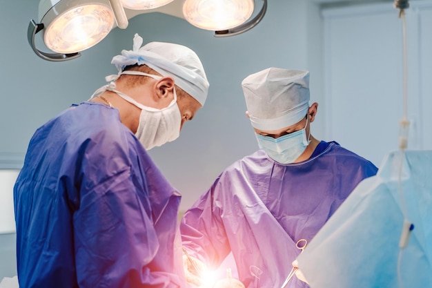 Foto in chirurgia equipe medica che esegue l'operazione nella sala operatoria dell'ospedale lavorare con strumenti chirurgici
