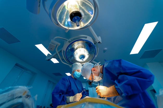 Photo in surgery medical team performing operation in hospital operating theater working with surgical instruments