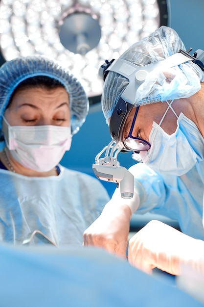 Концепция хирургии, медицины и людей. группа хирургов на операции в операционной комнате в больнице