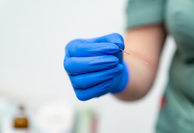 Surgery needle in gloved hands Hand holding syringe equipment