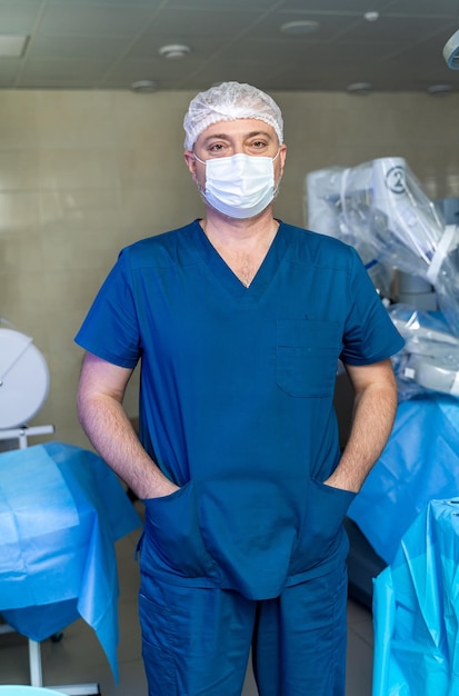 Специалист по хирургии стоит в маске и униформе Портрет врача в операционной