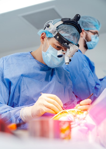 Surgery specialist working in modern hospital Professional surgeon operating with assistant