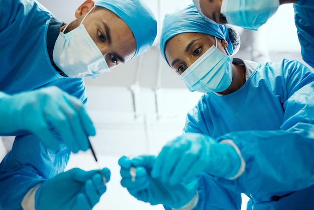 Surgery teamwork or doctors in a medical emergency operation theater with collaboration or team work helping a patient Support life insurance or focused healthcare workers in face masks working