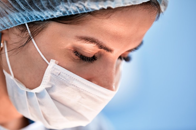 SurgeryThe face of a surgeon in a mask on the background of the operating room closeup of a working doctor Copy space operations modern medicine plastic surgery