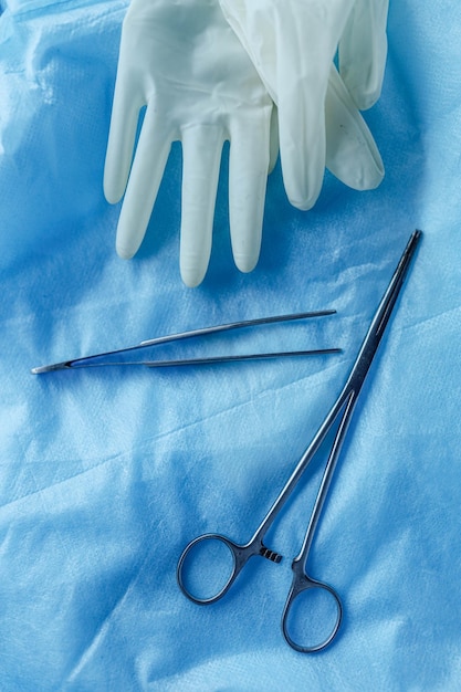 surgical instruments clamps and tweezers on a blue background in the operating room