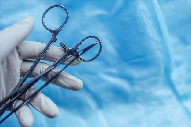 surgical instruments tweezers and clamps in the surgeon's hand