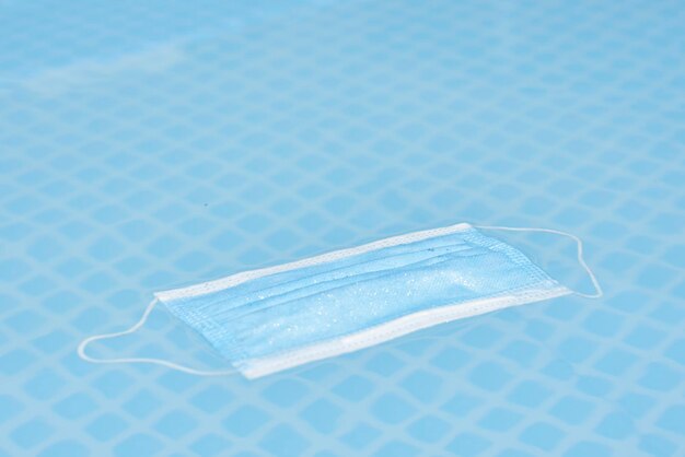 A surgical mask on a blue surface