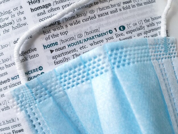 Photo surgical mask on a dictionary page highlights the word home