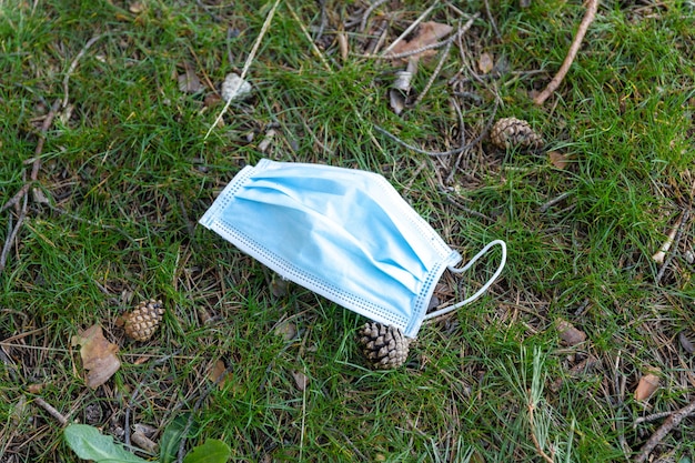 Surgical mask lying on the ground in the grass