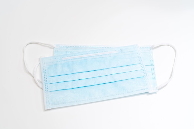 Surgical mask with rubber ear straps. Typical 3-ply surgical mask to cover the mouth and nose. Procedure mask from bacteria. Protection concept.