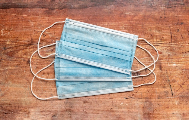 Surgical masks on worn wooden background, coronavirus concept