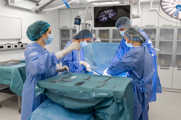 현대 수술실에서 수술을 수행하는 외과 팀 수술 중 환자에게 집중하는 의사 팀 수술실에서 수술하는 동안 함께 일하는 의사 팀