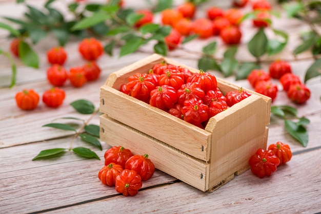 Suriname cherries in a small wooden box on a wooden surface