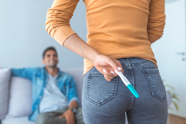 Surprise darling! Woman is hiding pregnancy test behind her back.