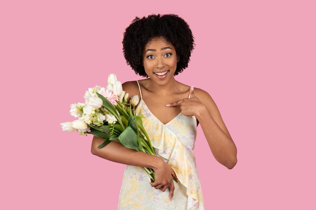 Surprised african american woman with flowers and bag