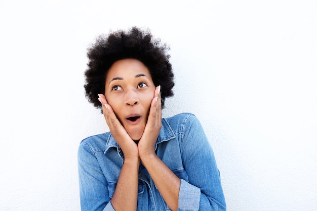 Surprised african woman holding face in hands