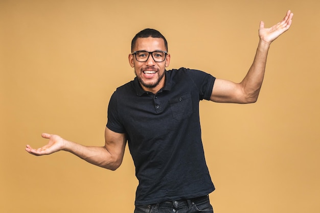 Surprised amazed shocked african american man guy in casual isolated over beige background studio portrait People lifestyle concept Mock up copy space Keeping mouth open