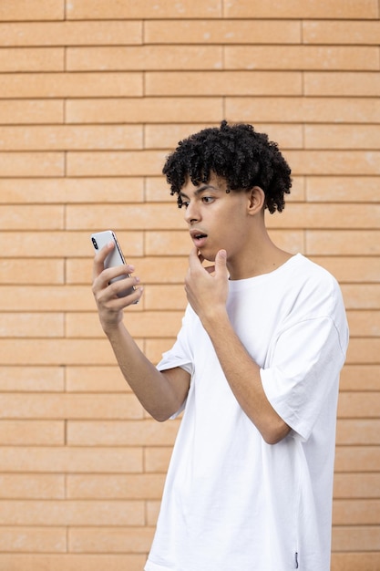 A surprised American man holding a phone and seeing his company's score during an online meeting