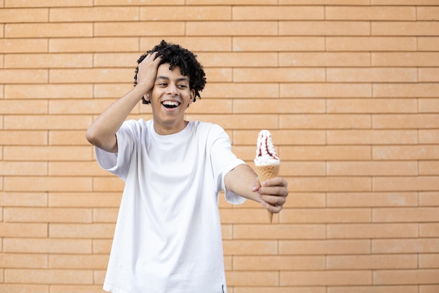 A surprised American man holding a white ice cream cone on an outstretched arm and with hand in hair