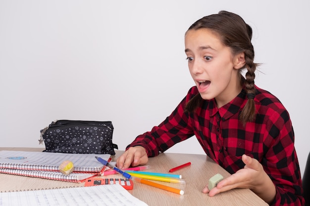 Surprised and angry girl doing the homework of the school