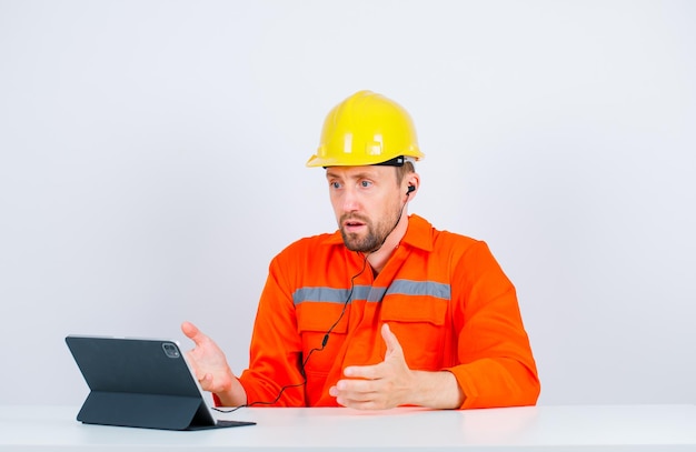 Surprised architect man is looking at tablet screen on white background