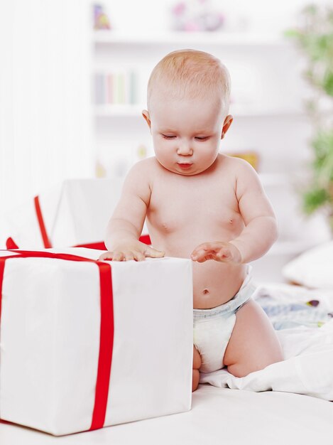 Surprised baby playing with gift boxes