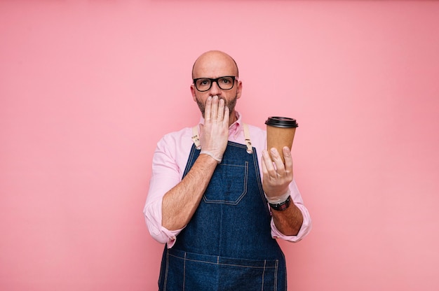 Surprised bald mature man with coffee in recyclable cardboard cup