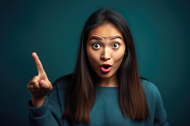 Surprised beautiful girl pointing finger over blue background