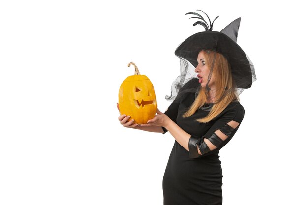 Foto sorpresa bella donna con jacko'lantern nelle sue mani e in cappello di strega nera sfondo bianco festa di halloween