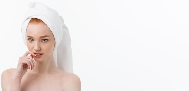 Foto sorpreso giovane e bella donna dopo il bagno con un asciugamano in testa isolato su sfondo bianco sci
