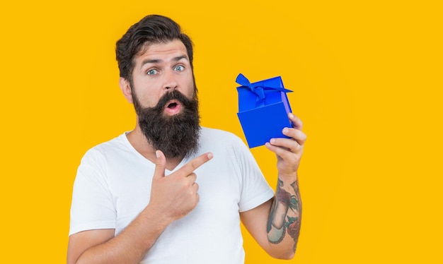 Surprised birthday guy holding present box bearded guy with\
present box in studio