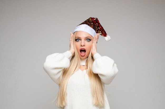 Surprised blonde woman in santa hat