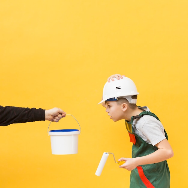 Surprised boy holding painting roller