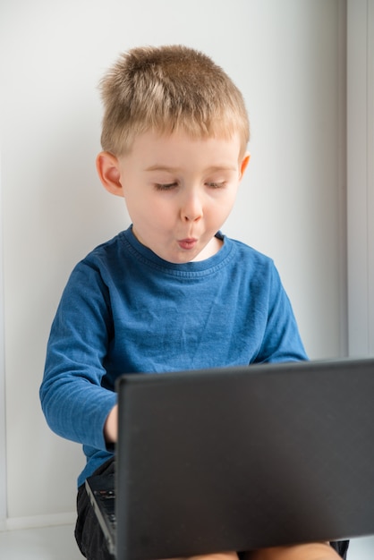 Surprised boy looking on the laptop screen