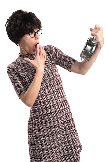 Surprised brunette girl holding vintage clock