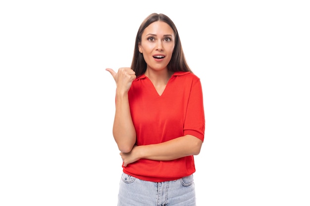 Surprised brunette woman in a red stylish vneck blouse shows her hand to the empty space